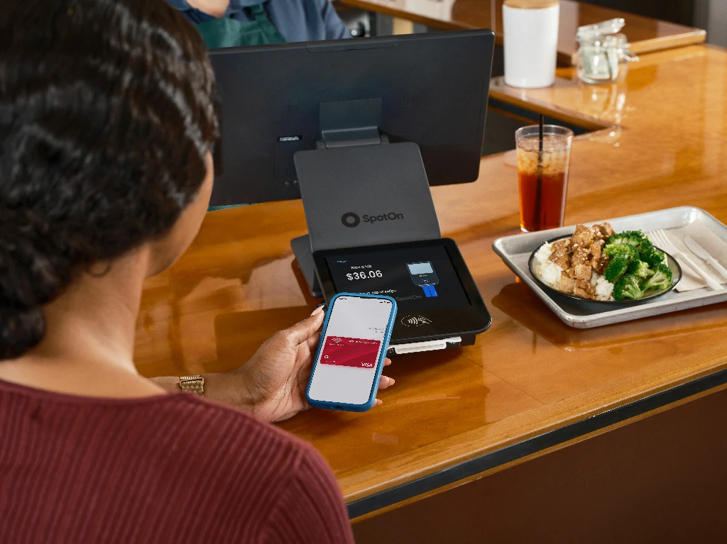 Thao tác chạm điện thoại vào máy POS để thanh toán Apple Pay