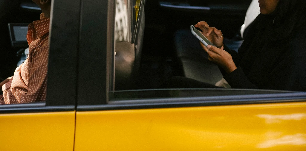 Du khách đang sử dụng điện thoại kiểm tra biển số xe taxi đón